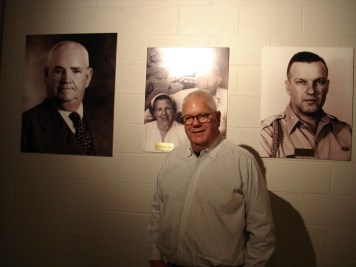 Peerless Corky Taylor in front of photos of L R his great grandfather Henry Krane grandparents and father e1455047195882